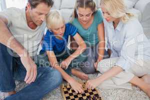 Portrait of a cute family playing chess