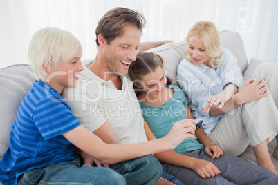 Family sitting on a couch and looking at a photo