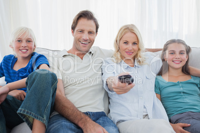 Parents posing with children and watching television
