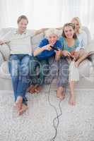 Children playing video games together sitting on the couch