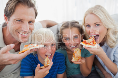Smiling family eating pizza