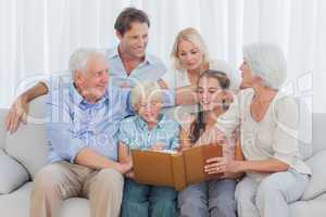 Extended cheerful family looking at a photo album