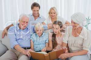 Extended family looking at an album photo
