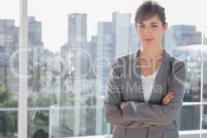 Happy businesswoman beside large window