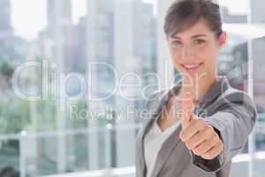 Smiling businesswoman giving thumb up at camera