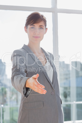 Businesswoman with hand out for handshake and smiling