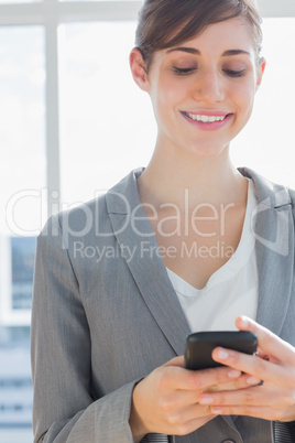 Businesswoman texting and smiling