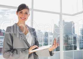 Businesswoman working on laptop and smiling at camera