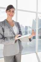 Businesswoman holding laptop and smiling
