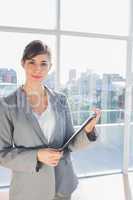 Businesswoman holding clipboard and smiling at camera