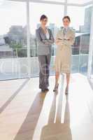 Confident businesswomen standing in bright office