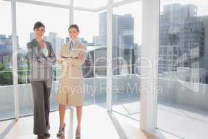 Smiling businesswomen standing in bright office