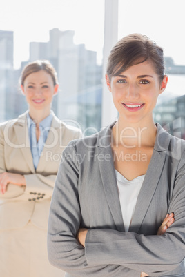 Two smiling businesswomen looking at camera with arms crossed Two smiling businesswomen looking at camera with arms crossed