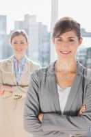 Two smiling businesswomen looking at camera with arms crossed