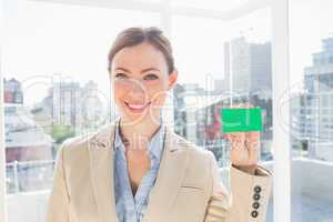 Smiling businesswoman showing green business card