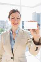 Smiling businesswoman holding up blank business card