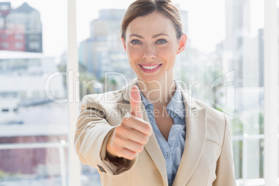 Happy businesswoman giving thumb up to camera