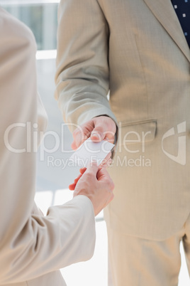 Businessman handing card to businesswoman