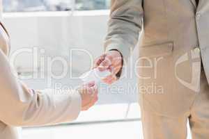 Businessman passing card to businesswoman