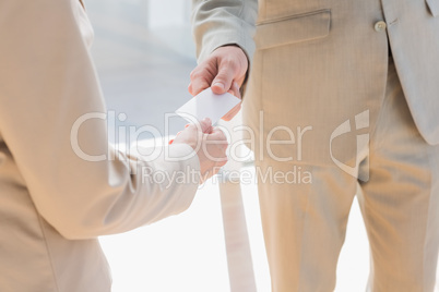 Businessman passing white card to businesswoman