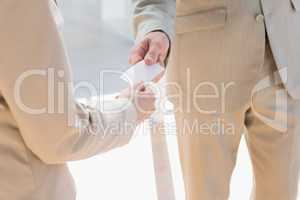 Businessman passing white card to businesswoman