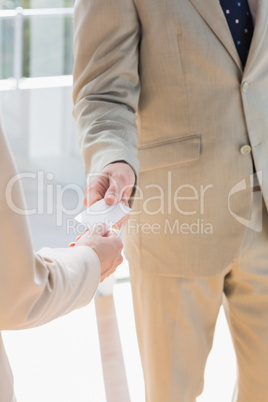 Businessman passing blank card to businesswoman