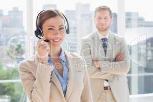 Happy call centre agent with colleague behind her