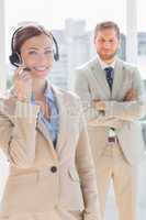 Pretty call centre agent with colleague behind her