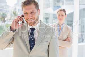 Smiling businessman on the phone looking at the camera