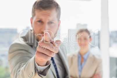 Angry businessman pointing at camera