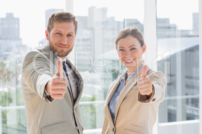 Smiling business team giving thumbs up