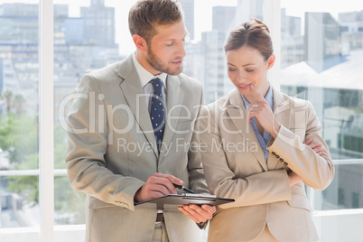 Business partners going over document on clipboard