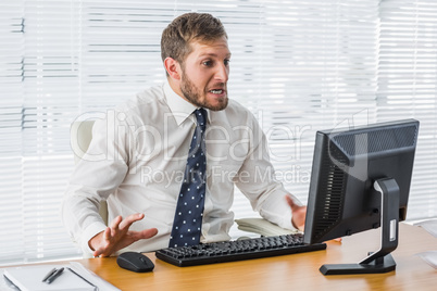 Frustrated businessman looking at his computer