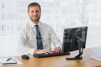 Businessman sitting at desk smiling Businessman sitting at desk smiling