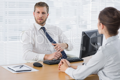 Businessman meeting with a colleague at his desk