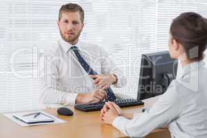 Businessman meeting with a colleague at his desk