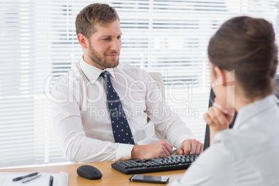 Businessman meeting with a co worker at his desk