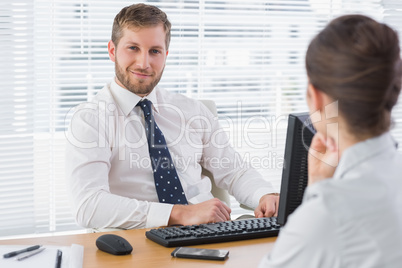 Businessman sitting with a co worker at his desk