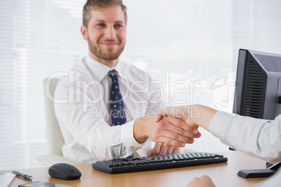 Happy businessman shaking hands with a co worker