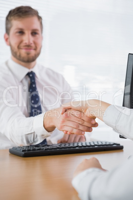 Smiling businessman shaking hands with a co worker