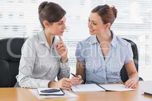 Smiling businesswomen working together on documents
