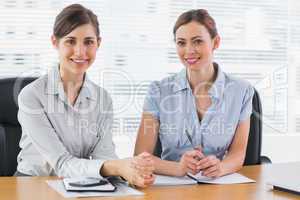 Happy businesswomen working together and smiling at camera