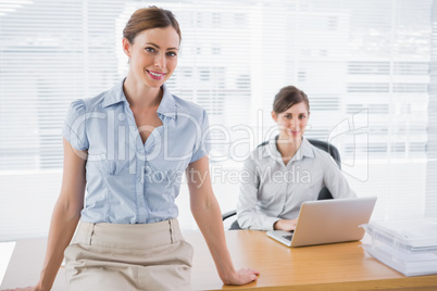 Businesswomen smiling at camera in their office