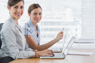 Young businesswomen working on their laptops portrait