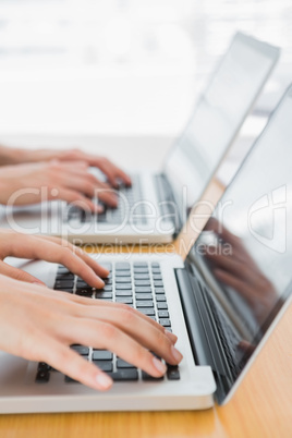 Hands of businesswomen typing