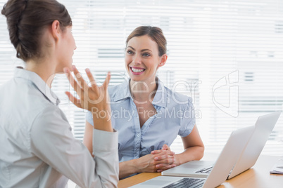 Businesswomen talking at their desk