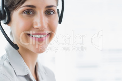 Brunette call centre agent smiling at the camera