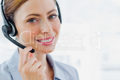 Call centre operator wearing headset smiling at camera