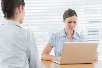Businesswoman looking at laptop during an interview