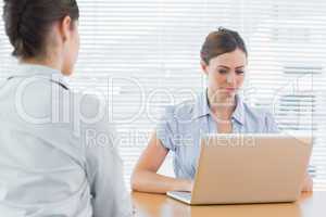 Businesswoman looking at laptop during an interview